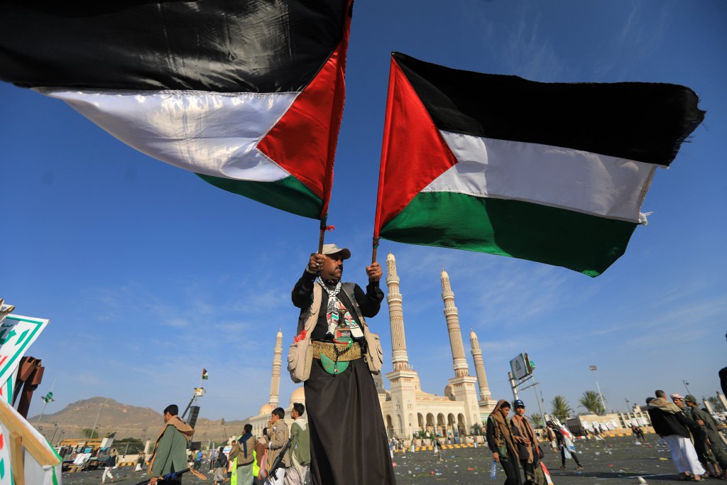 A supporter of Yemen's Huthis waves Palestinian flags during a rally condemning Israel and in support of Palestinians, near the Saleh Grand Mosque in the Huthi-held capital Sanaa on October 3, 2025. (Photo by Mohammed HUWAIS / AFP)