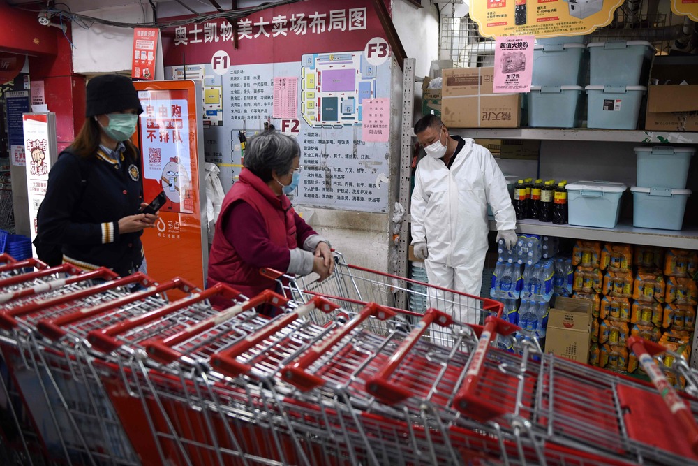 A supermarket employee makes sure shoppers in Beijing keep a meter from each other while queueing. A supermarket employee makes sure shoppers in Beijing keep a meter from each other while queueing.