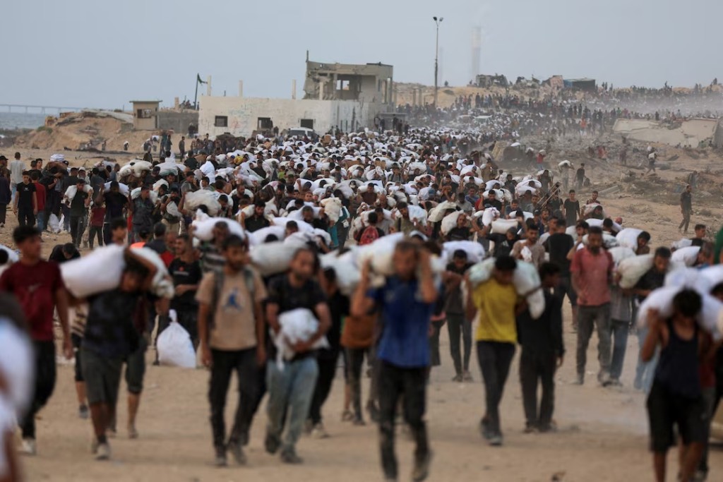 Palestinians carry aid supplies, that entered Gaza on trucks through Israel, in Beit Lahia, in the northern Gaza Strip July 29, 2025. REUTERS/Dawoud Abu Alkas/File Photo