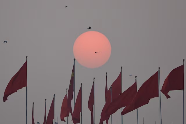 Sun rises near a Chinese national flag on the day of the closing session of the Chinese People's Political Consultative Conference (CPPCC) at the Great Hall of the People in Beijing, China March 10, 2025. REUTERS/Tingshu Wang/File Photo