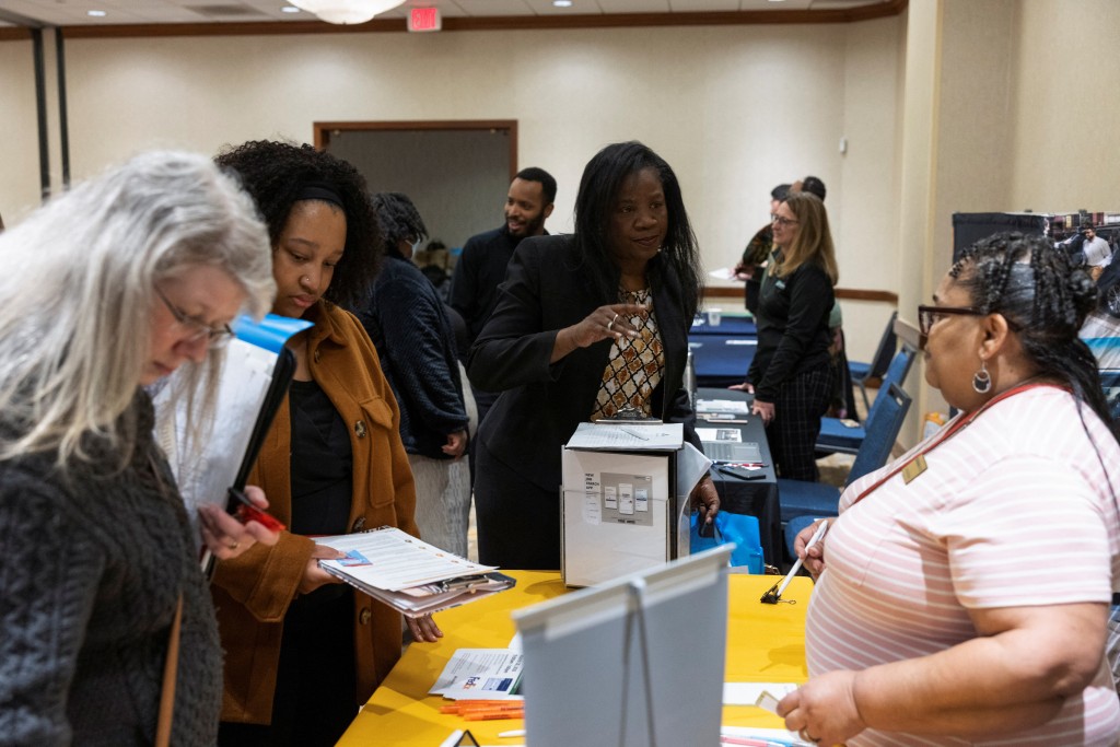 Paulette Phillips speaks with Nancy McNealy of KansasWorks during a job fair for federal workers fired in recent weeks through job cuts, organized by the National Treasury Employees Union (NTEU) in Kansas City, Missouri, U.S. March 15, 2025. Phillips is currently a federal employee working at the IRS, she's at the job fair to research backup employment opportunities in the event she is fired. REUTERS/Chase Castor