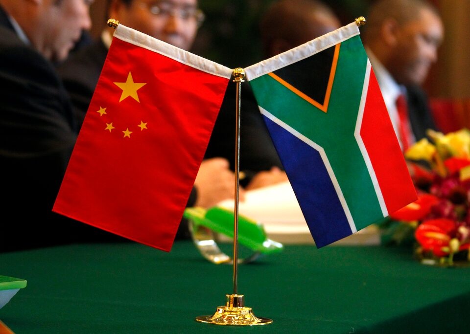  The South African and Chinese national flags sit atop a table as businessmen sign contracts during the China-South Africa Business Forum in Beijing August 24, 2010. REUTERS/David Gray/ File Photo 