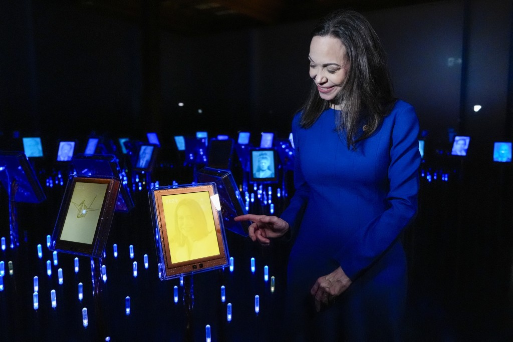 Photo by LISE ÅSERUD / NTB / AFP Nobel Peace Prize laureate Maria Corina Machado shows her picture on display during the opening of the official Peace Prize exhibition at the Nobel Peace Center in Oslo, Norway, on December 11, 2025.