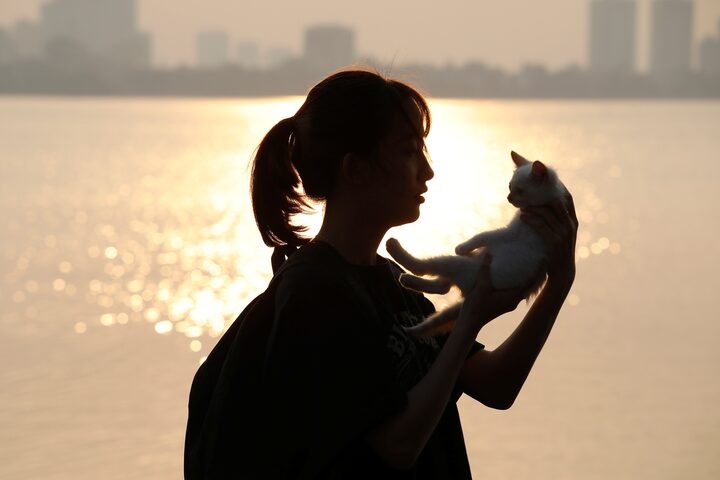 A girl plays with a cat by the Westlake after the government eased the nationwide lockdown during the coronavirus disease (COVID-19) outbreak in Hanoi, Vietnam April 28, 2020. REUTERS/Kham