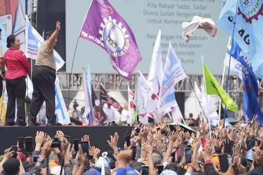 Indonesian President Prabowo Subianto, second left, throws his shirt to the crowd during a May Day rally at the National Monument in Jakarta, Indonesia, Thursday, May 1, 2025. (AP Photo/Tatan Syuflana)[ASSOCIATED PRESS/Tatan Syuflana]