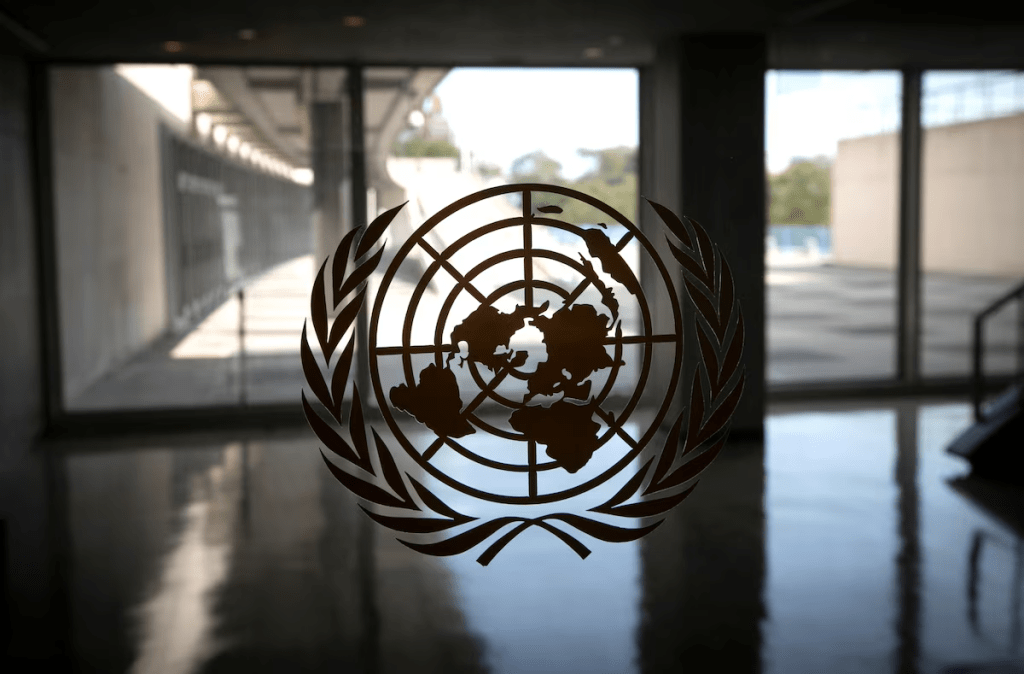 The United Nations logo is seen on a window in an empty hallway at United Nations headquarters during the 75th annual U.N. General Assembly high-level debate, which is being held mostly virtually due to the coronavirus disease (COVID-19) pandemic in New York, U.S., September 21, 2020. REUTERS/Mike Segar/File Photo