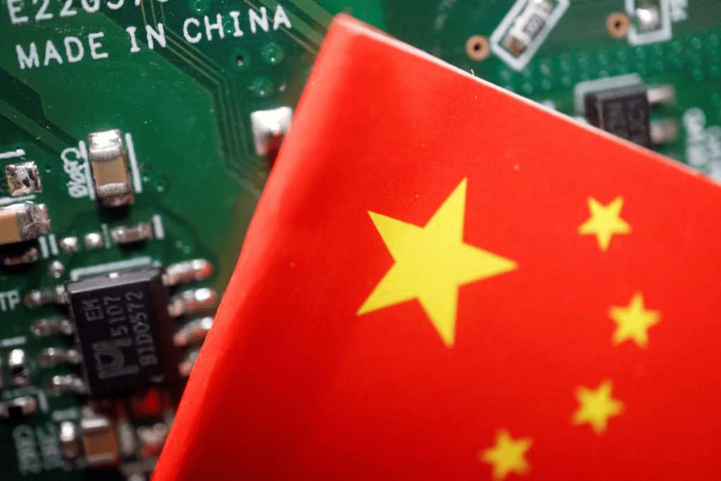 A Chinese flag is displayed next to a "Made in China" sign seen on a printed circuit board with semiconductor chips, in this illustration picture taken February 17, 2023. REUTERS/Florence Lo/Illustration