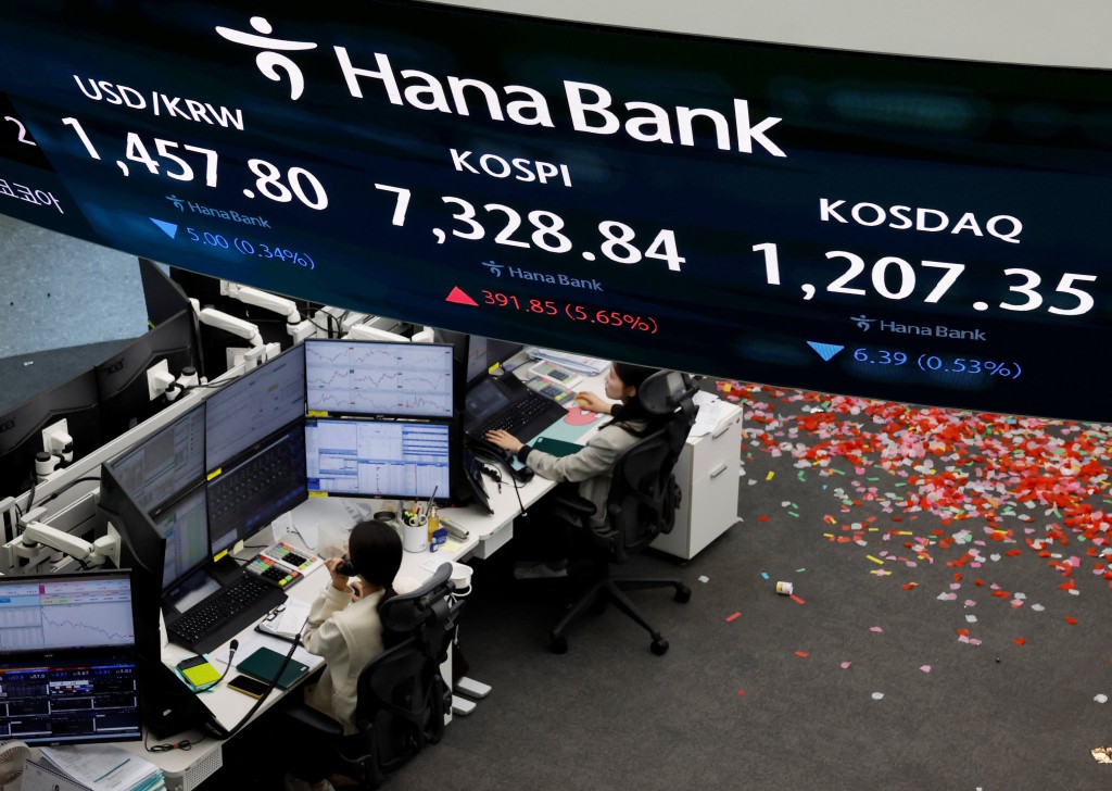 Currency dealers work as an electronic board displays the Korea Composite Stock Price Index (KOSPI), the exchange rate between the U.S. dollar and South Korean won and the Korea Securities Dealers Automated Quotations (KOSDAQ) at the dealing room of a bank, as the benchmark KOSPI index opened above the 7,000 mark in Seoul, South Korea, May 6, 2026. REUTERS