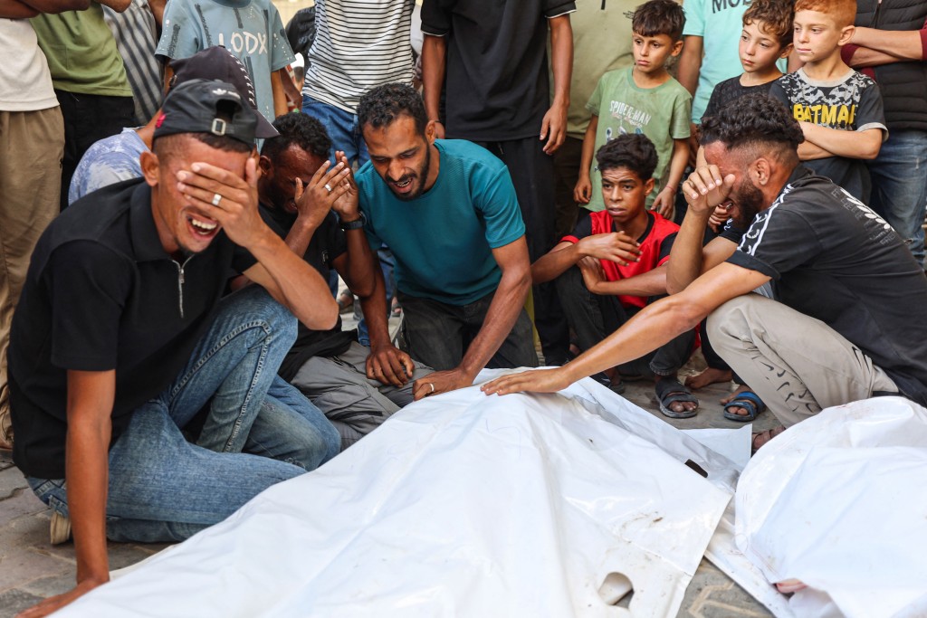 Photo by OMAR AL-QATTAA / AFP Mourners grieve next to the bodies of three Palestinians during their funeral at Al Shifa Hospital in Gaza City on October 25, 2026, after they were killed in an Israeli strike on the Islamic University building.