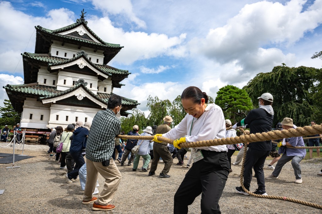 Participants pull Hirosaki Castle using ropes to its original position following repair works in Hirosaki, Aomori Prefecture on August 26, 2026. (Photo by Philip FONG / AFP)