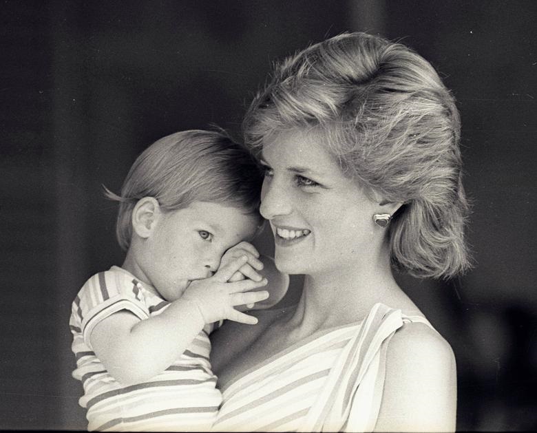 Young Prince Harry tries to hide behind his mother during a morning picture session at Marivent Palace, August 9, 1988. REUTERS/Hugh Peralta. 