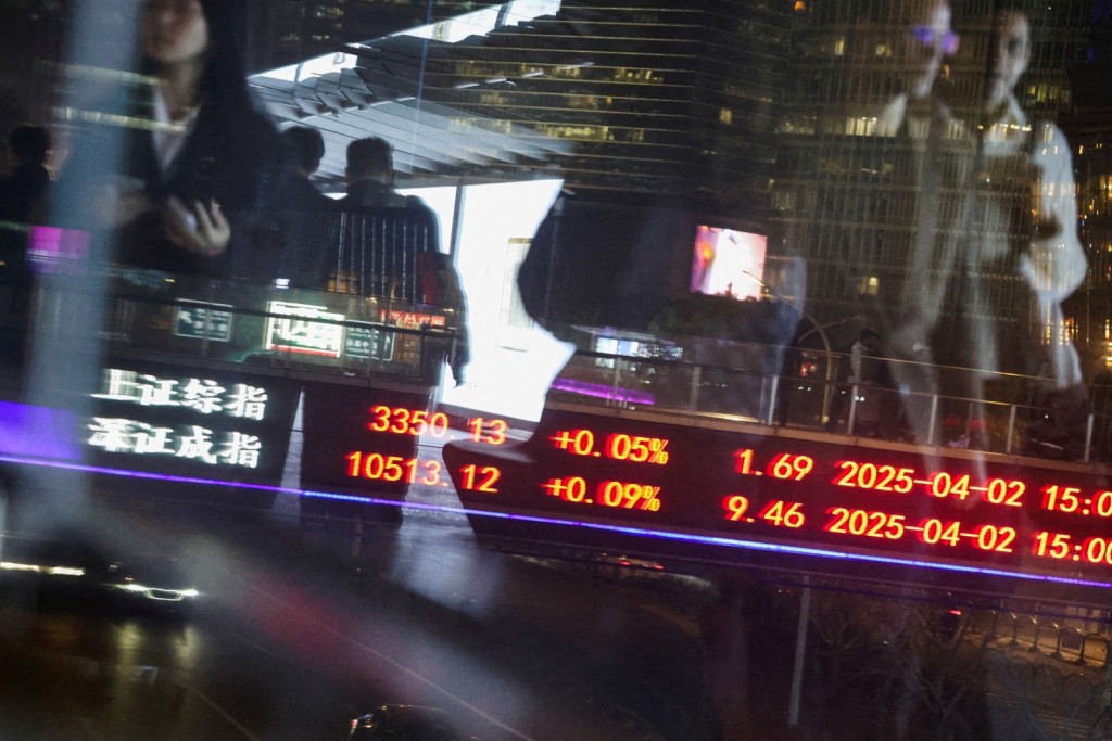 An electronic board shows Shanghai and Shenzhen stock indices as people walk on a pedestrian bridge at the Lujiazui financial district in Shanghai, China. REUTERS