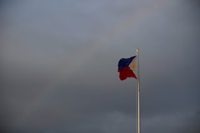Philippines National Flag is pictured as the rainbow displays over it a day before the annual procession to celebrate Black Nazarene feast day at Quirino Grandstand in Manila, Philippines, January 8, 2020. REUTERS/Willy Kurniawan/File Photo