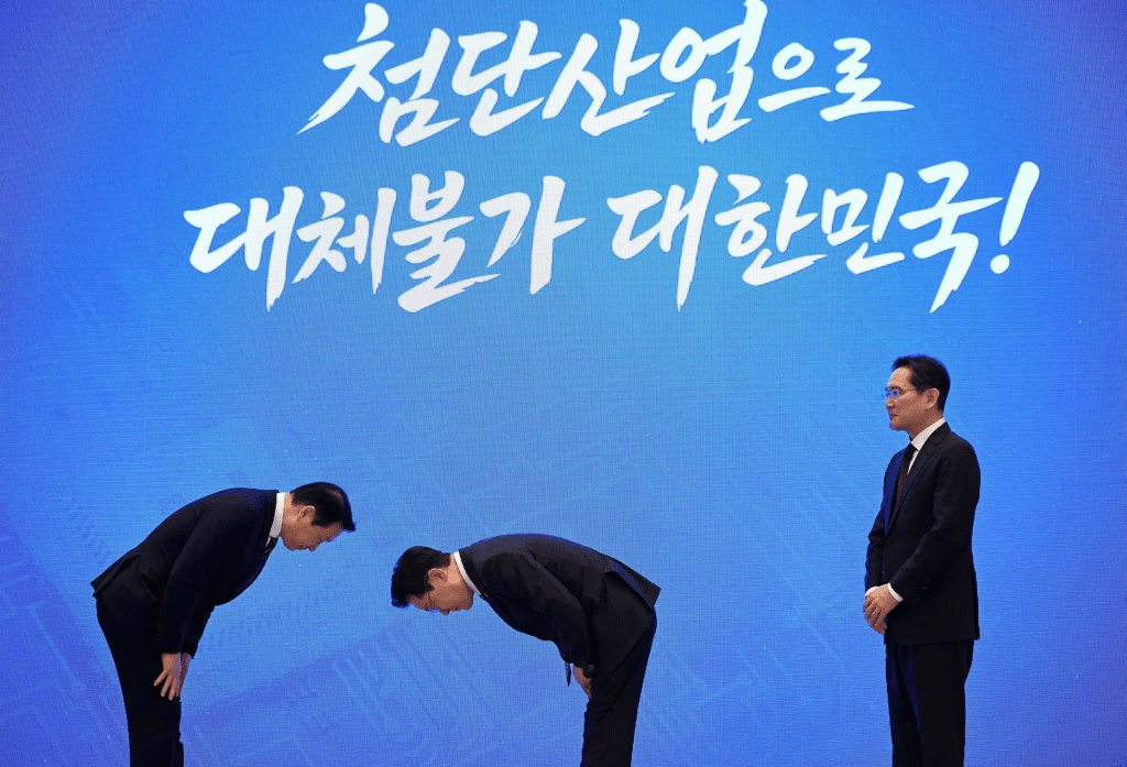 South Korean President Lee Jae Myung and SK Group Chairman Chey Tae-won bow to each other as Samsung Electronics Chairman Lee Jae-yong observes after a briefing announcing the government's three mega projects at Yeongbingwan, the Blue House, in Seoul, South Korea, June 29, 2026. Kim Min-Hee/Kyodonews/Pool via REUTERS/File Photo