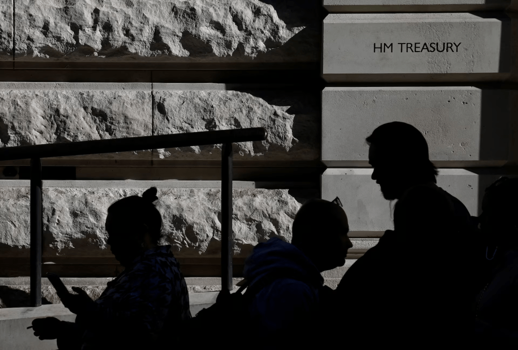 People walk past the Treasury building in London, Britain, October 11, 2022. REUTERS/Toby Melville