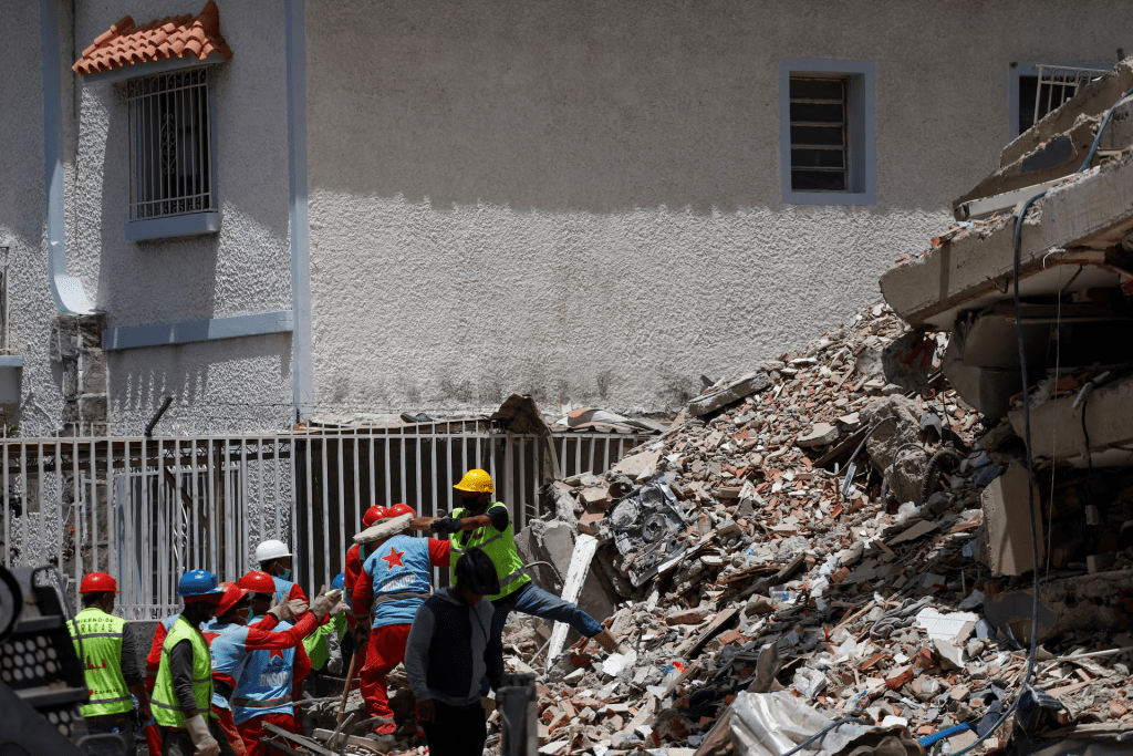 Rescuers search for people under the rubble of a collapsed building following earthquakes that hit the country, in Caracas, Venezuela, June 26, 2026. REUTERS/Fausto Torrealba
