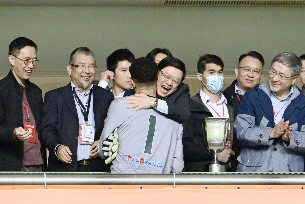 John Lee is one excited fan as he hugs former England goalkeeper David James during the trophy ceremony. SING TAO John Lee is one excited fan as he hugs former England goalkeeper David James during the trophy ceremony. SING TAO