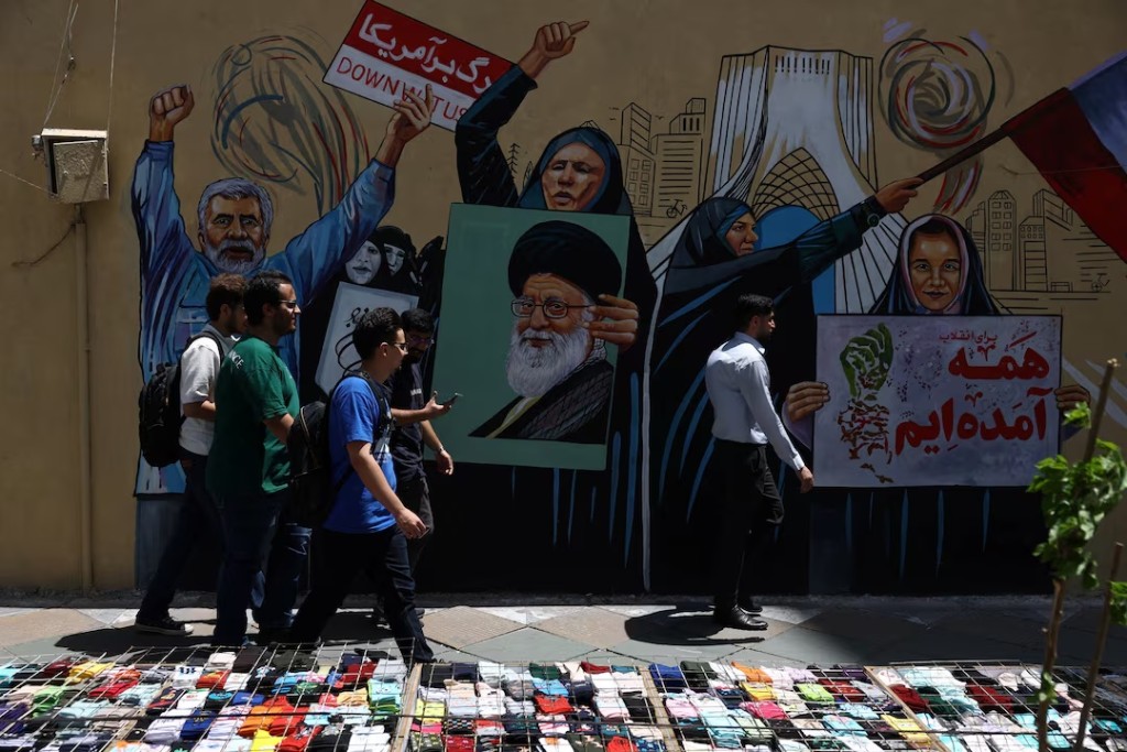  People walk on a street near a mural featuring an image of the late Supreme Leader of Iran, Ayatollah Ali Khamenei, in Tehran, Iran, May 6, 2026. Majid Asgaripour/WANA (West Asia News Agency) via REUTERS