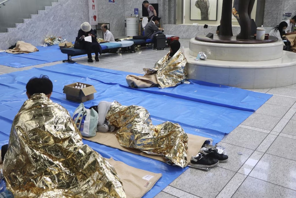  People stay at a makeshift evacuation centre set up at the Chiba prefectural government office for those unable to return home, as public transportation is disrupted following torrential rain in Chiba, Chiba Prefecture, Japan, August 14, 2026. Kyodo/via REUTERS 