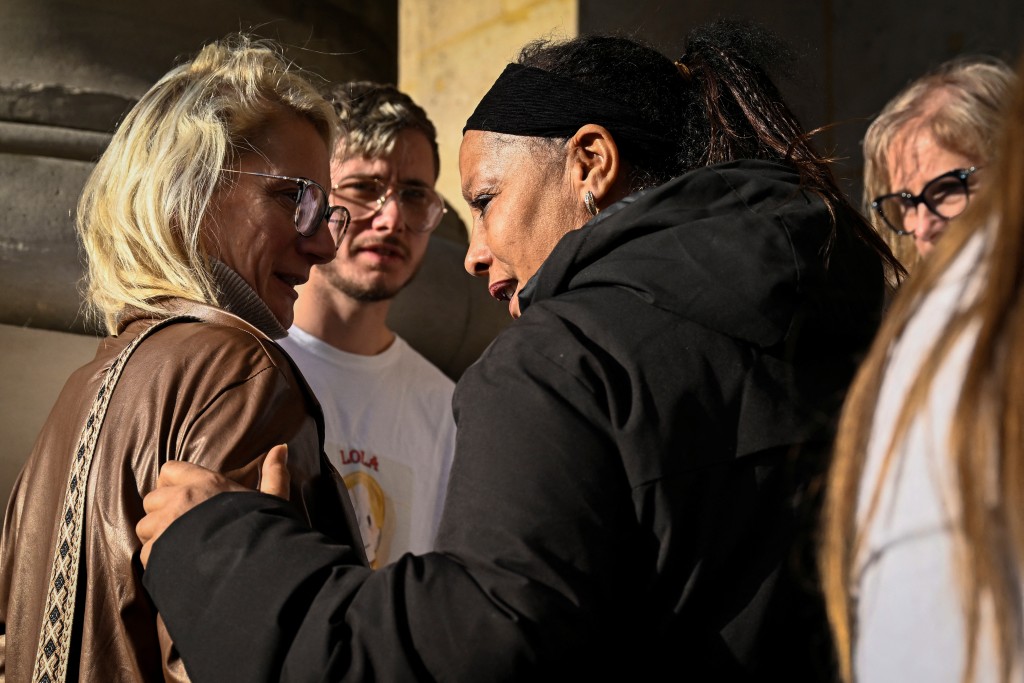 Delphine Daviet (L), mother of Lola, speaks with people came to support her during a recess in the trial of Dahbia Benkired, accused of raping, torturing, and killing Lola Daviet, a 12-year-old girl, in 2022, at the Paris Assize Court on October 17, 2025. (Photo by JULIEN DE ROSA / AFP)