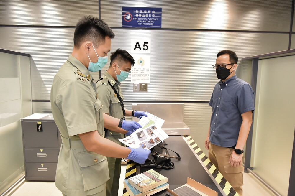 Suspected terrorism-related articles being found by Customs officers from a passenger's belongings during the drill.