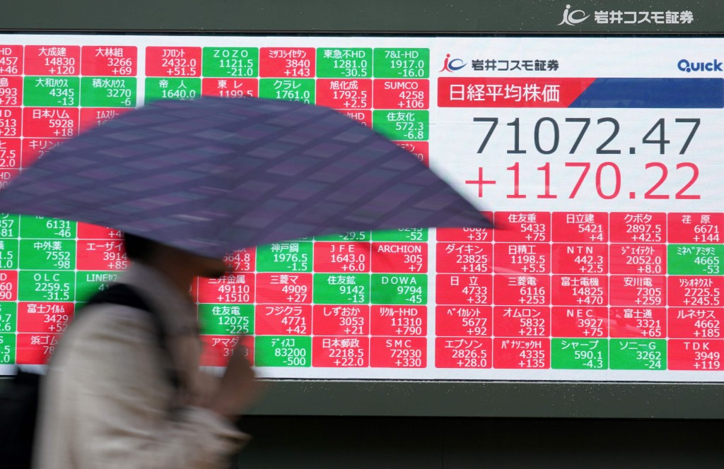 A man walks past an electronic quotation board displaying the Nikkei Stock Average on the Tokyo Stock Exchange in Tokyo on June 18, 2026. AFP