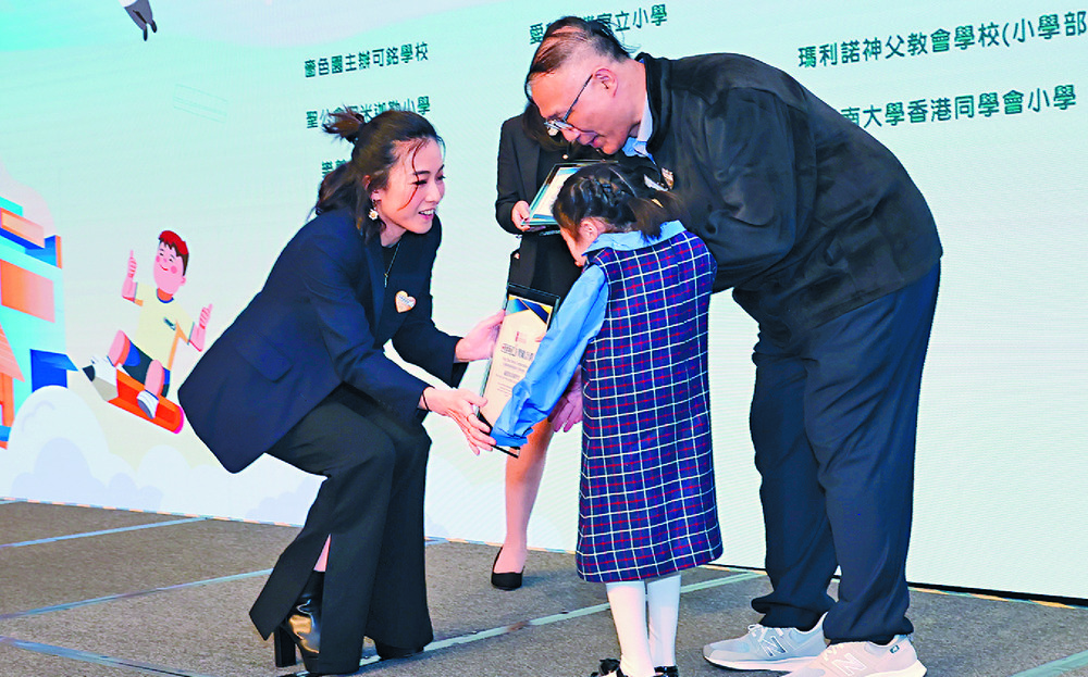 Kimbee Lau welcomes a shy child to the stage. SING TAO