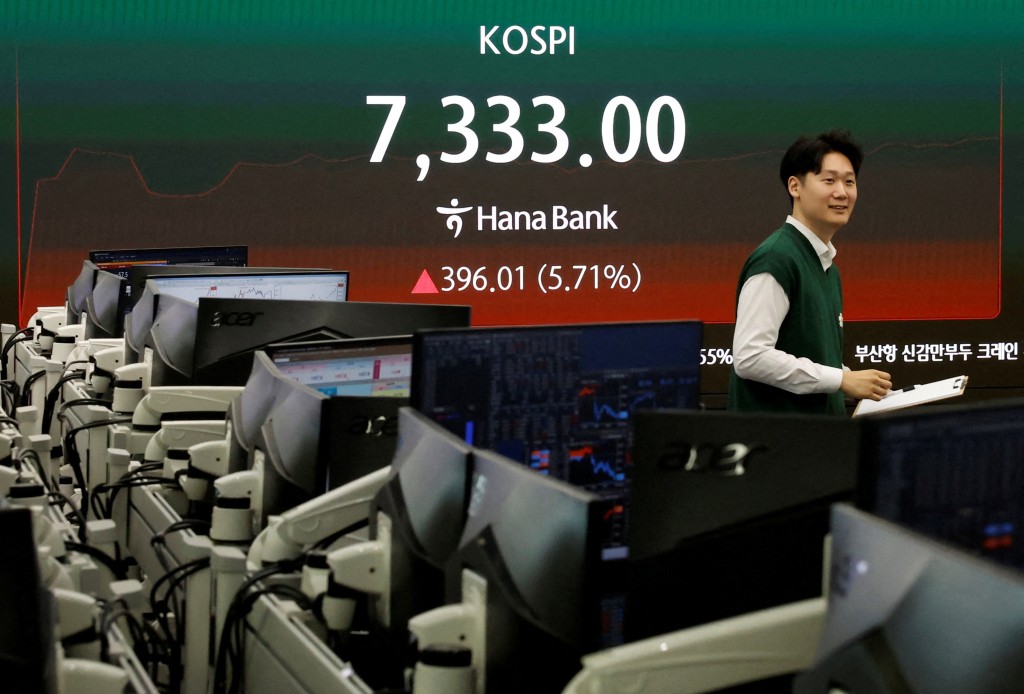 A currency dealer looks on as an electronic board displays the Korea Composite Stock Price Index (KOSPI), at the dealing room of a bank, as the benchmark KOSPI index opened above the 7,000 mark in Seoul, South Korea, May 6, 2026. REUTERS