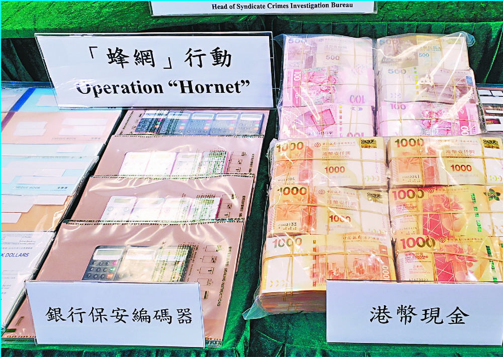 Seized cash and bank cards and a chart showing how the operation works. SING TAO Seized cash and bank cards and a chart showing how the operation works. SING TAO