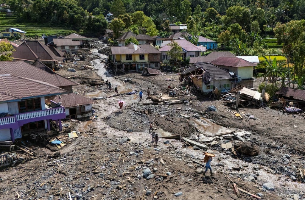  A drone view of local residents carrying their belongings recovered from their homes in an area affected by a deadly landslide following heavy rains in Malalak, Agam regency, West Sumatra province, Indonesia, December 3, 2025. REUTERS/Willy Kurniawan