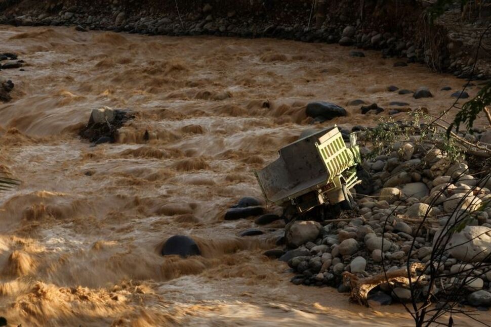 A truck is stranded in the river at an area hit by deadly flash floods following heavy rains in Padang, West Sumatra province, Indonesia, November 30, 2025. REUTERS/Willy Kurniawan