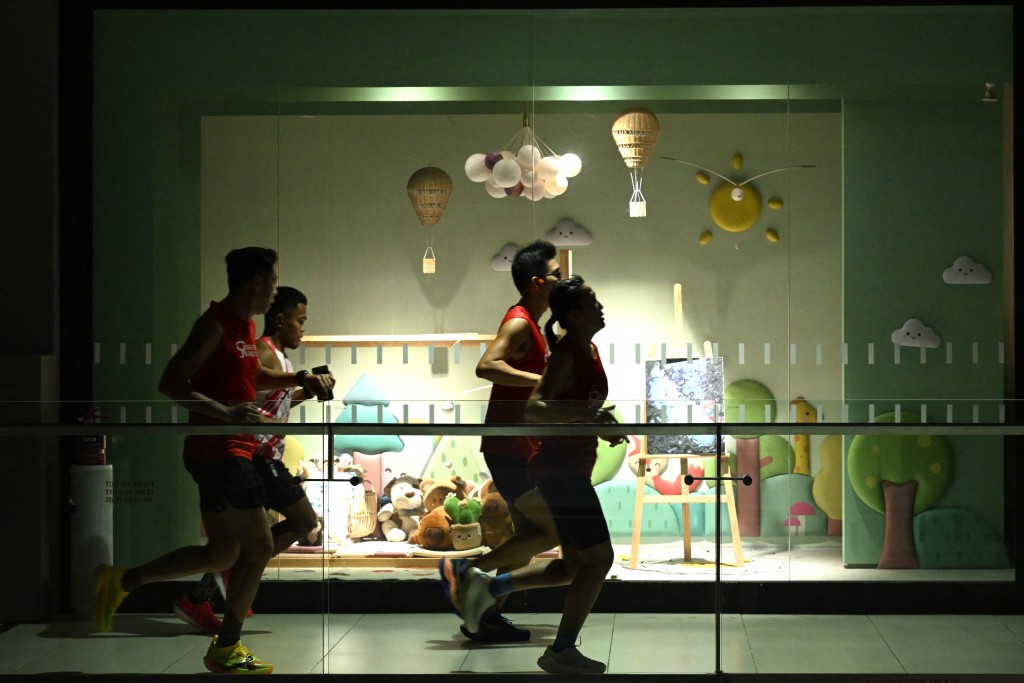 Photo by ROSLAN RAHMAN / AFP  Fitness enthusiasts run inside a mall due to haze situation outside in Singapore on October 24, 2026.