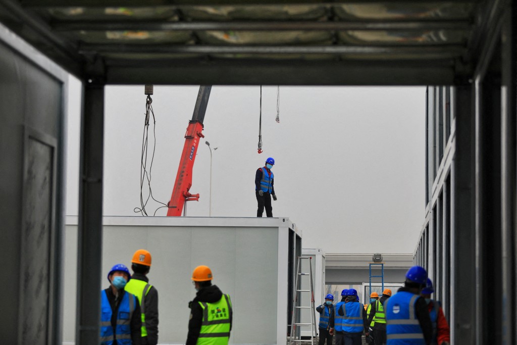 FILE PHOTO: Workers are seen at the construction site of a makeshift hospital being built to quarantine related personnel and treat patients of the coronavirus disease (COVID-19) when necessary, in Baqiao district of Xian, Shaanxi province, China January 5, 2022. Picture taken January 5, 2022. China Daily via REUTERS