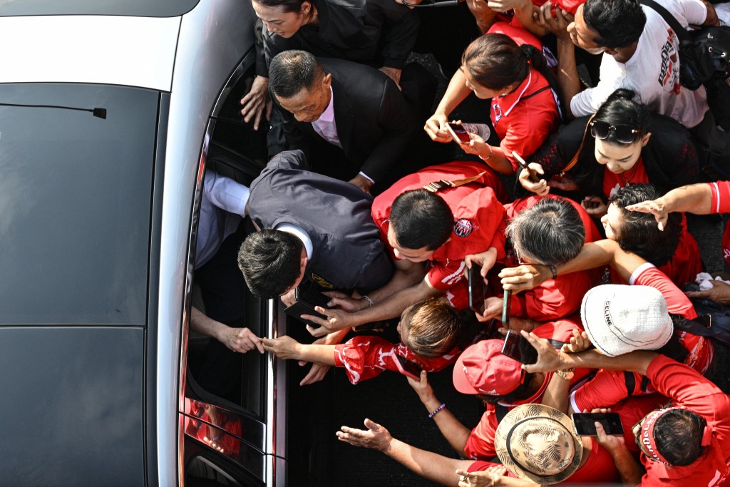 Thailand's former prime minister Thaksin Shinawatra (L) greets his supporters as he leaves in a car after his release from Klong Prem Central Prison in Bangkok on May 11, 2026. (AFP)