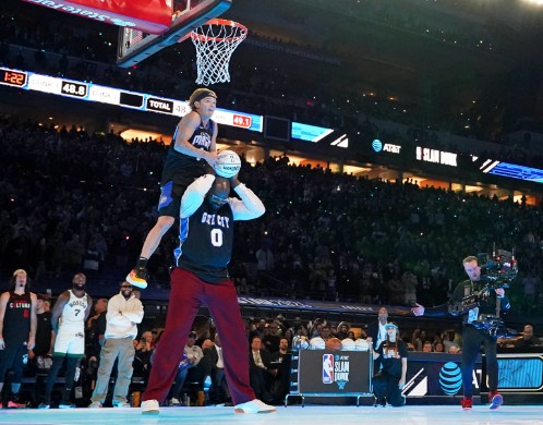 Shaquille O’Neal helps Mac McClung during the slam dunk contest at an NBA All Star Game. REUTERS