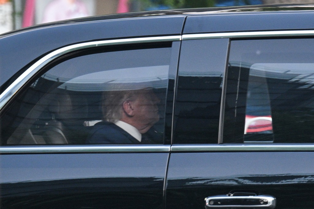 US President Donald Trump is seen in his official vehicle known as "The Beast" as the motorcade drives through Beijing on their way for a state banquet on May 14, 2026. (Photo by HECTOR RETAMAL / AFP)