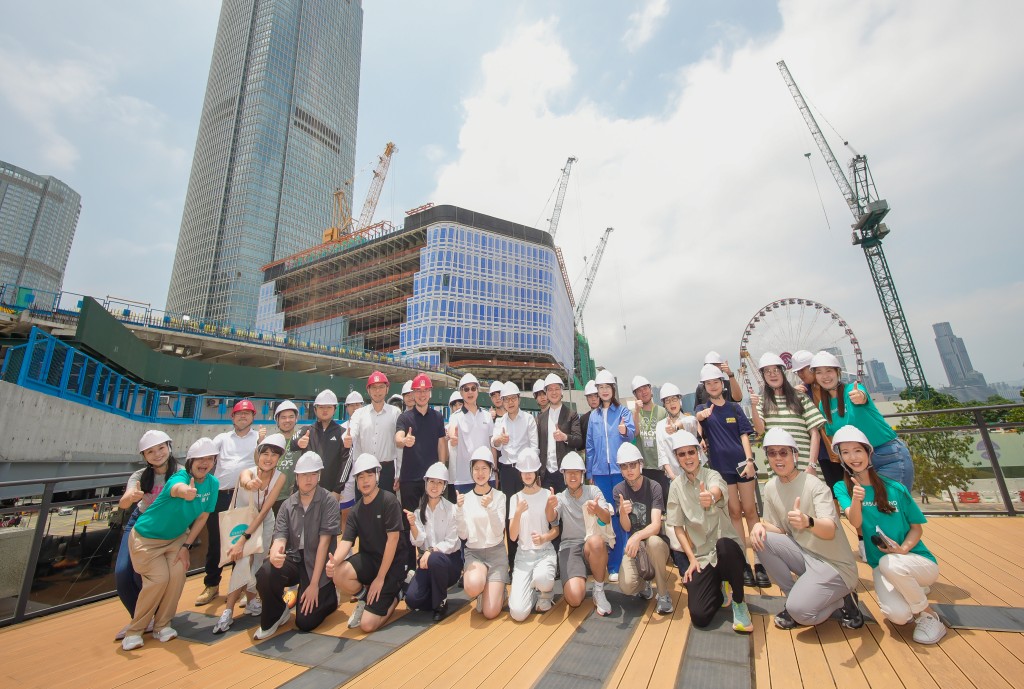 Group photo, taken in front of Central Yards during construction, of the distinguished guests, and participating programme mentors and mentees. Henderson Land.