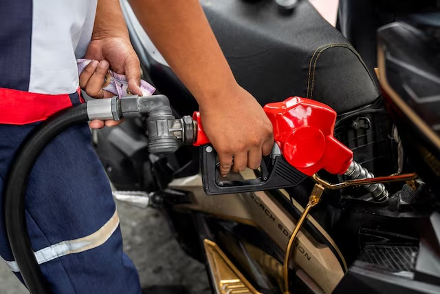 A worker fills up a motorcycle at a gas station as oil prices are expected to increase amid the U.S.-Israel conflict with Iran, in Quezon City, Metro Manila, Philippines, March 9, 2026. REUTERS/Lisa Marie David 