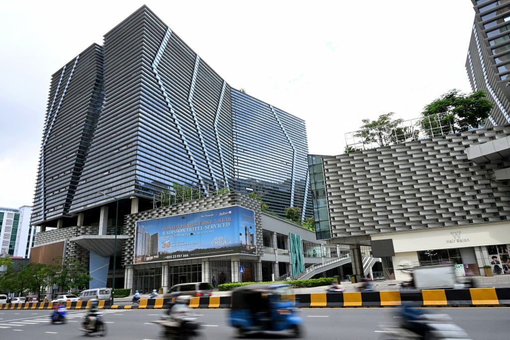 Vehicles drive past the Prince International Plaza in Phnom Penh on October 15, 2025.  Photo by TANG CHHIN SOTHY / AFP