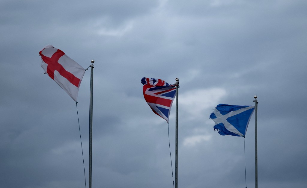 National flags of England, Great Britain and Scotland are blown by strong winds as storm named Bram approaches New Brighton, Britain, December 9, 2025. REUTERS/Phil Noble