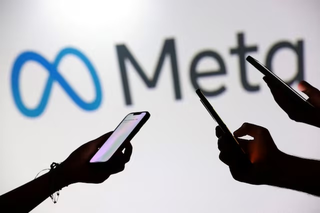 Teenagers pose for a photo while holding smartphones in front of a Meta logo in this illustration taken September 11, 2025. REUTERS/Dado Ruvic/Illustration/File Photo