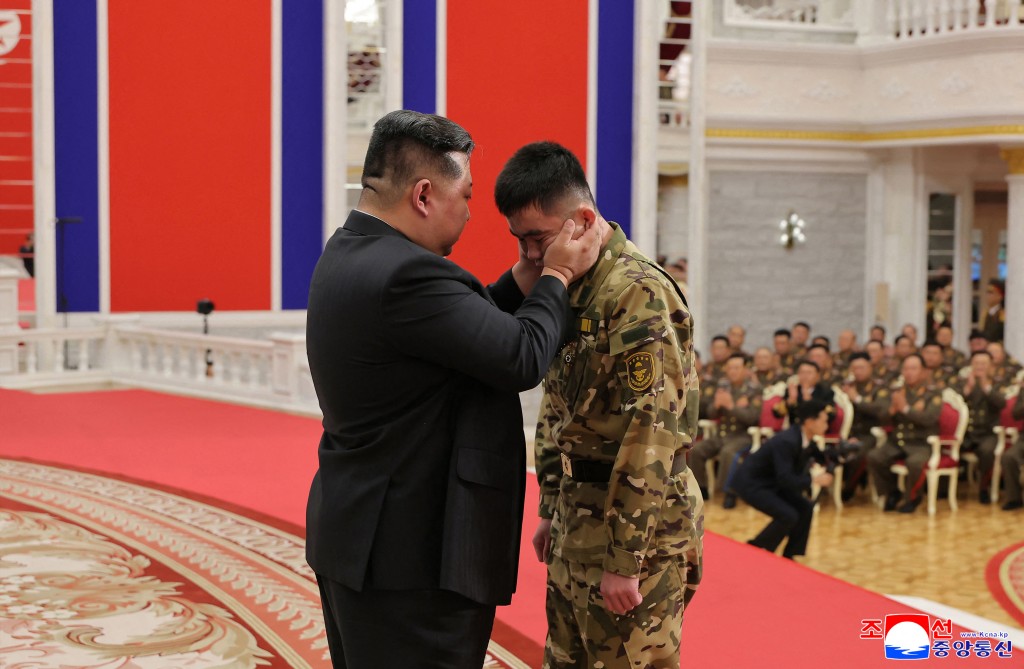 This undated picture released from North Korea's official Korean Central News Agency (KCNA) on August 22, 2025 shows North Korean leader Kim Jong Un (L) embracing a serviceman as he attends a ceremony to award state commendations to the commander and combatants of the Korean People's Army's Overseas Operational Forces.   (Photo by KCNA VIA KNS / AFP)