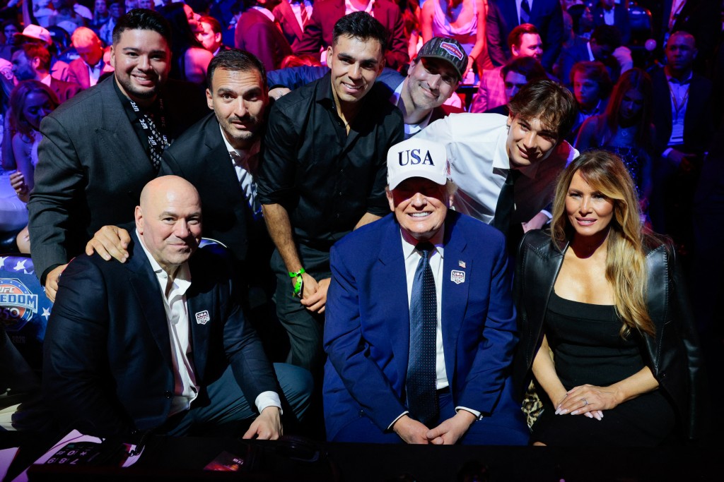 US President Donald Trump smiles as he sits next to US First Lady Melania Trump and UFC CEO Dana White while posing for a photo with other guests during UFC Freedom 250 on the South Lawn of the White House in Washington, DC, on June 15, 2026. (AFP)