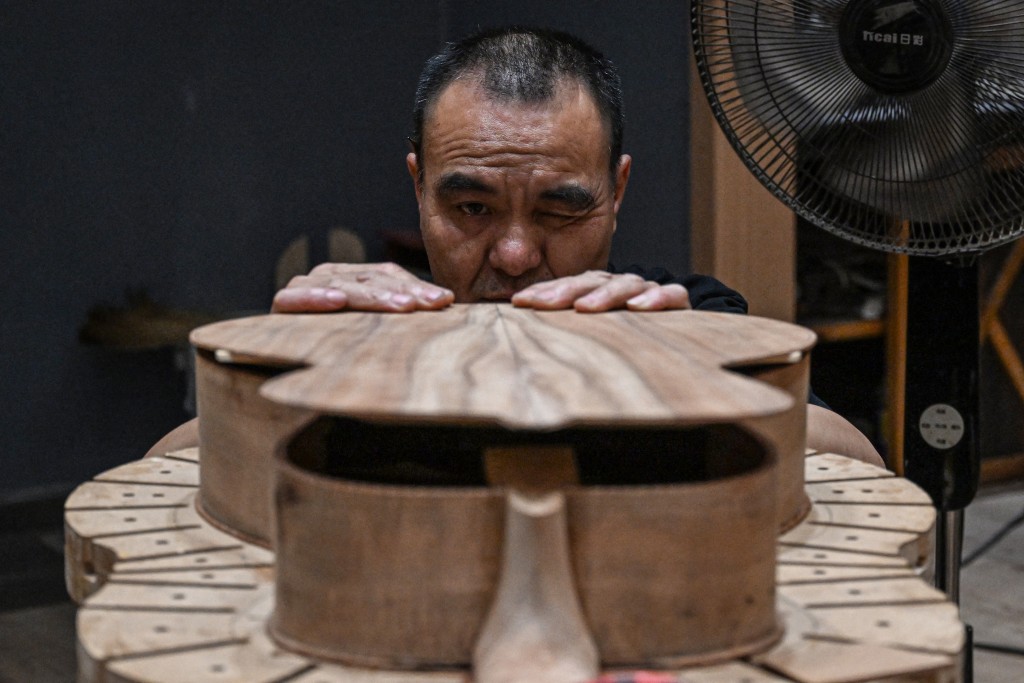 A worker making a guitar at a guitar workshop in Zheng'an, in southwestern China's Guizhou Province. (AFP)