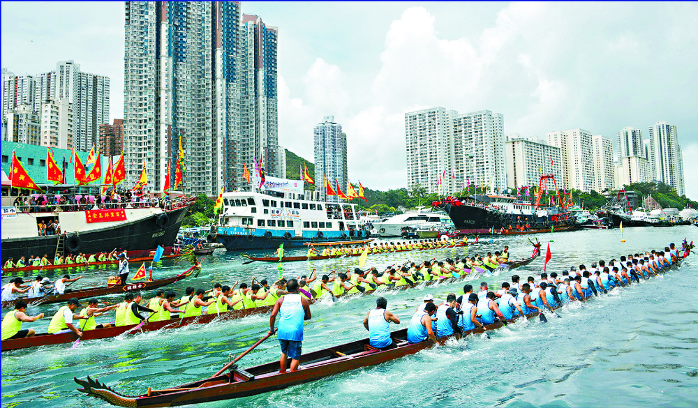Participants and spectators feel more 'engaged' at the Tuen Ng Festival as races are held in Aberdeen, Tai Po, Sai Kung and other places. Below: a child tries to satisfy his curiosity in Stanley. SING TAO