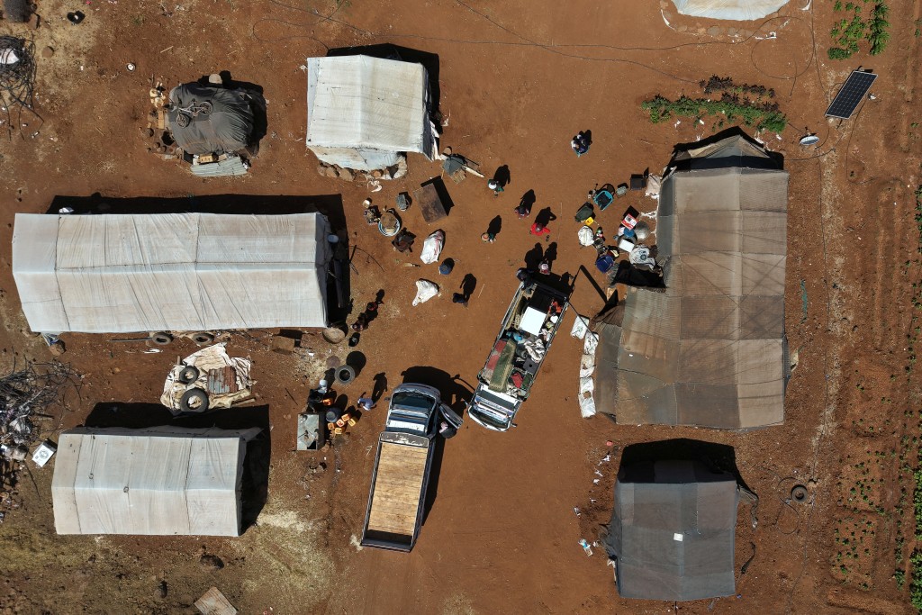 This aerial picture shows a view of Bedouin residents dismantling their camp in the vicinity of the Druze al-Mazraa village in Syria's southern Sweida gvernorate on July 17, 2025, as they prepare to leave for safer areas amid ongoing clashes. The southern Sweida province has been gripped by deadly sectarian bloodshed since July 13, with hundreds reportedly killed in clashes pitting Druze fighters against Sunni Bedouin tribes and the army and its allies. (Photo by Bakr ALKASEM / AFP)