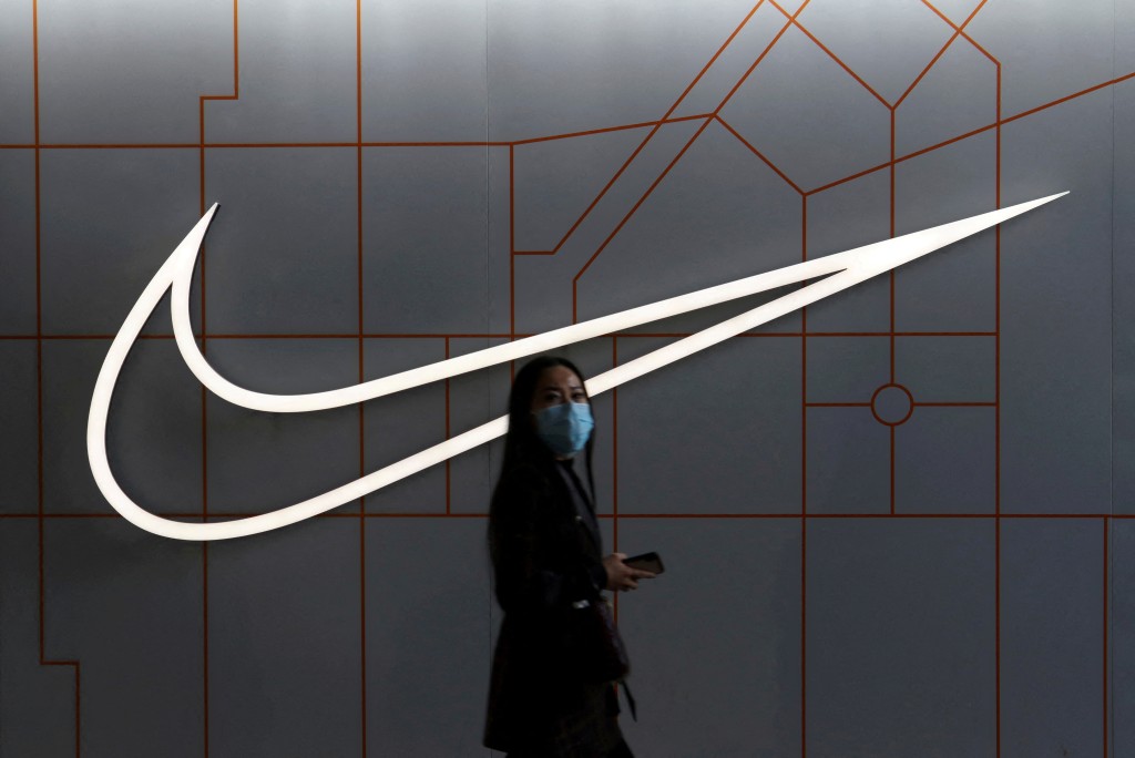 A woman walks past a store of the sporting goods retailer Nike Inc at a shopping complex in Beijing, China March 25, 2021. REUTERS/Florence Lo