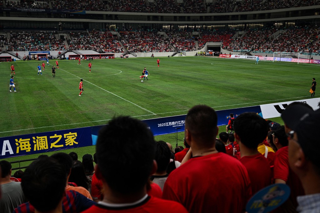 Fans watch the amateur league football match between Suzhou and Yangzhou at the Kunshan Olympic Sport Center in Kunshan, in eastern China's Jiangsu province on June 29, 2025. On a summer's day in the city of Suzhou, about 40,000 people crowded into a stadium while thousands more gathered by public screens to watch China's hottest sport -- amateur football. (Photo by Hector RETAMAL / AFP)