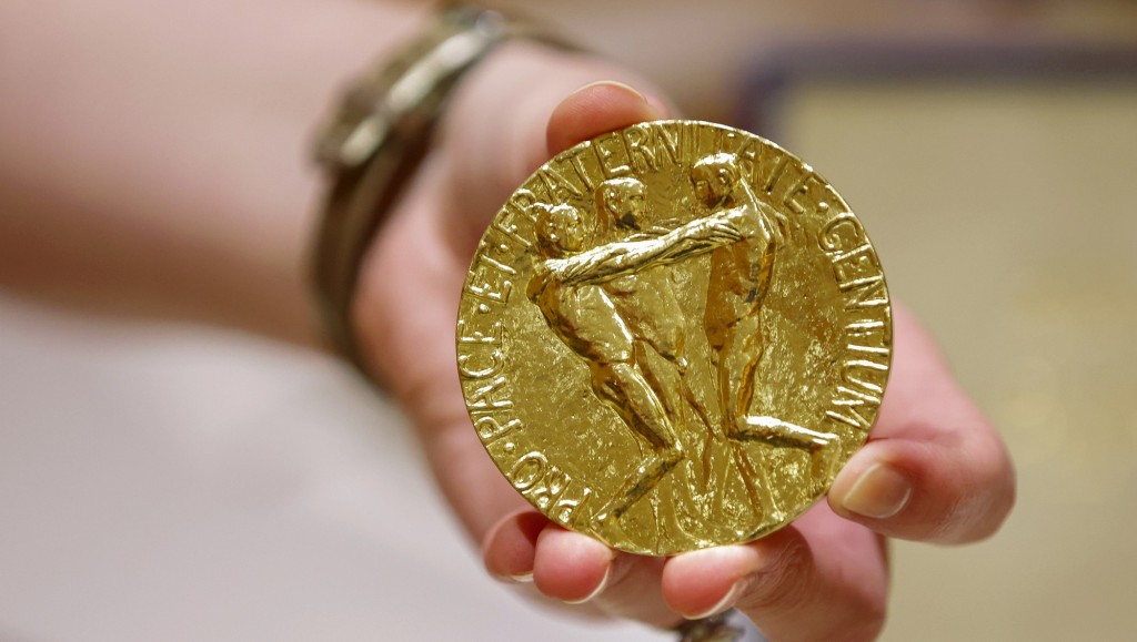 A worker holds Russian journalist Dmitry Muratov's 23-karat gold medal of the 2021 Nobel Peace Prize before being auctioned at the Times Center, Monday, June 20, 2022, in New York. (AP Photo/Eduardo Munoz Alvarez)
