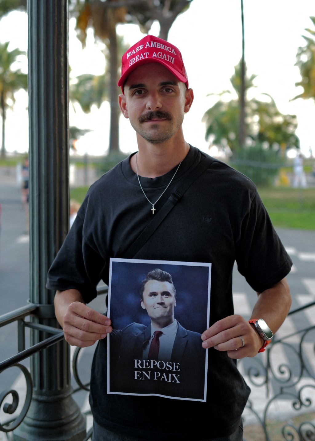 A man poses with a MAGA hat during a vigil in tribute to Turning Point USA Founder Charlie Kirk in the French Riviera city of Nice, on September 17, 2025. Kirk, a close ally of US President Donald Trump, was shot on September 10 during a speaking event on a Utah university campus. He was the founder of the hugely influential conservative youth political group Turning Point USA. (Photo by Valery HACHE / AFP)